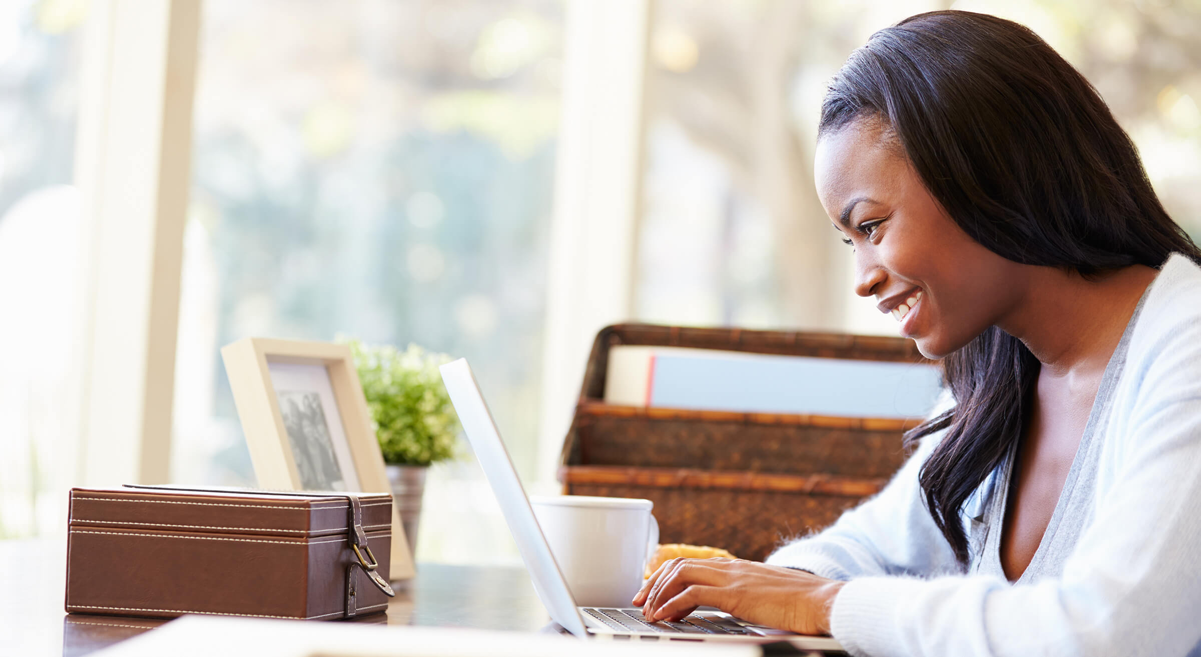 A smiling woman looking at a laptop