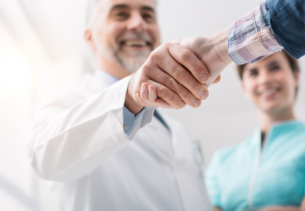 A doctor shaking hands with a patient