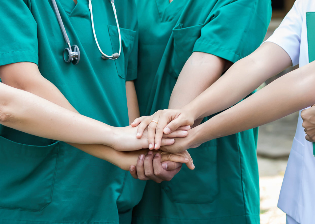 A group of medical professionals holding hands