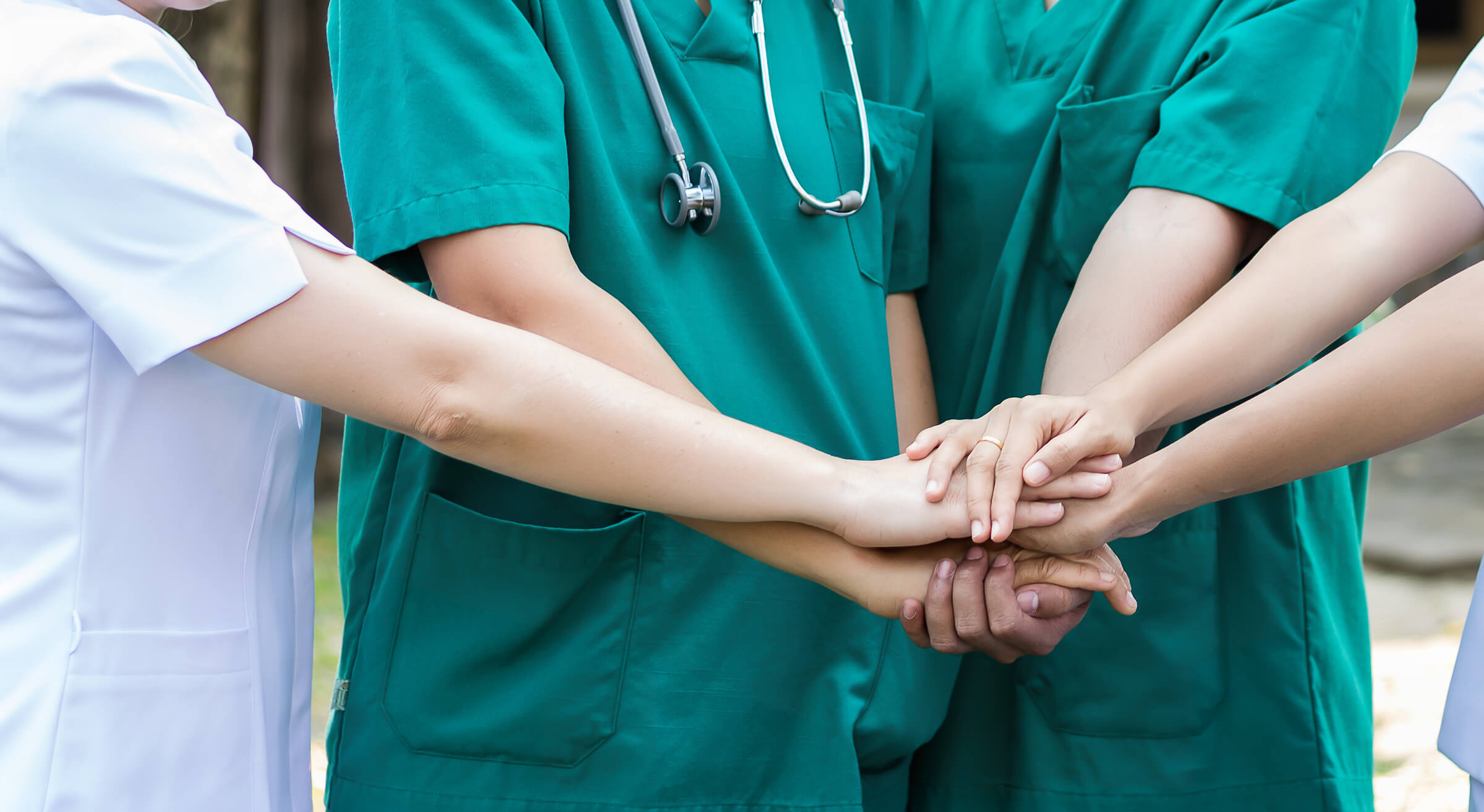A group of medical professionals holding hands